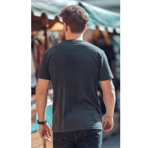 Man wearing a black t-shirt walking away from the camera in an outdoor setting.