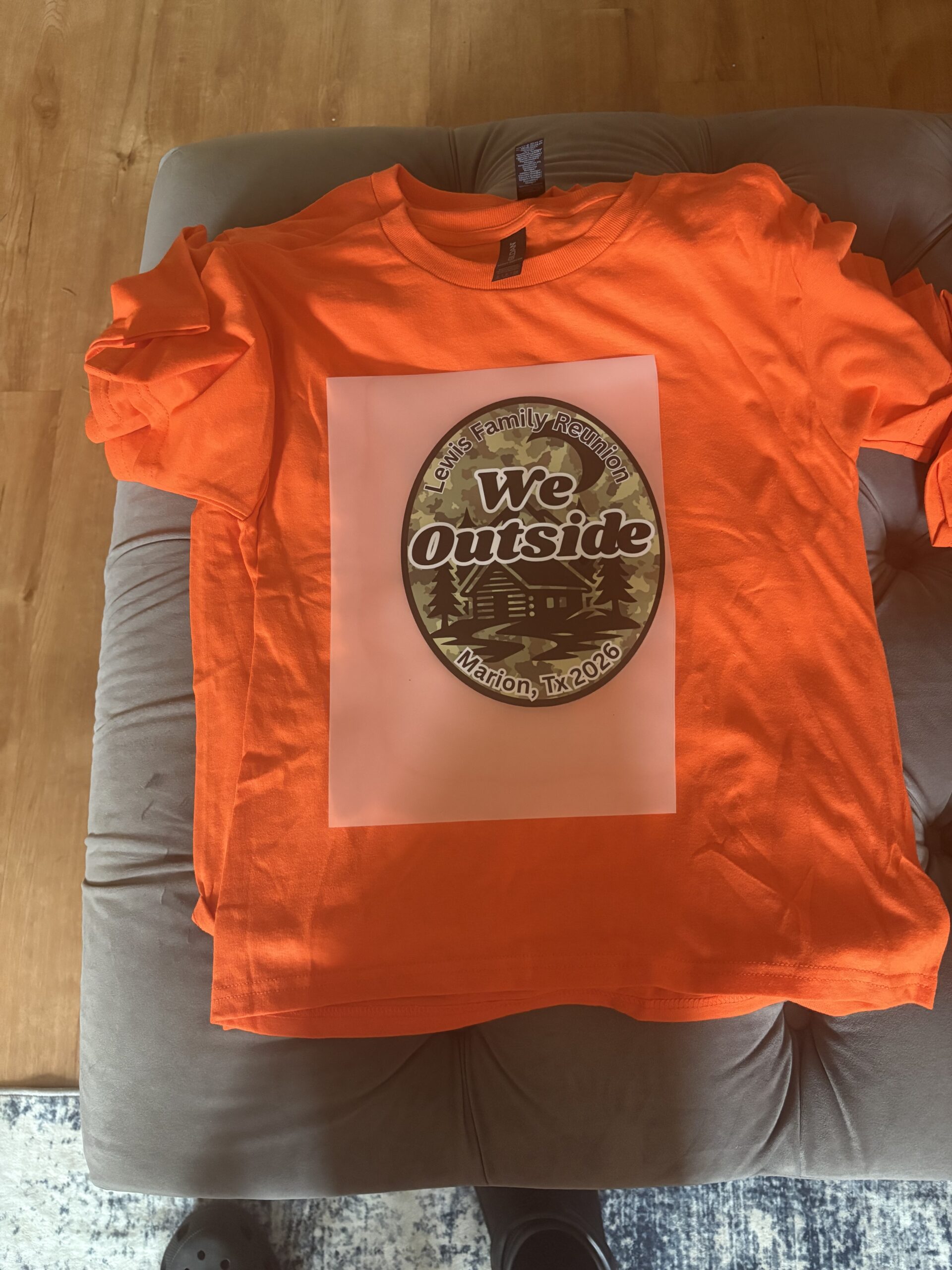 Portfolio DTF transfer positioned on an orange shirt before pressing